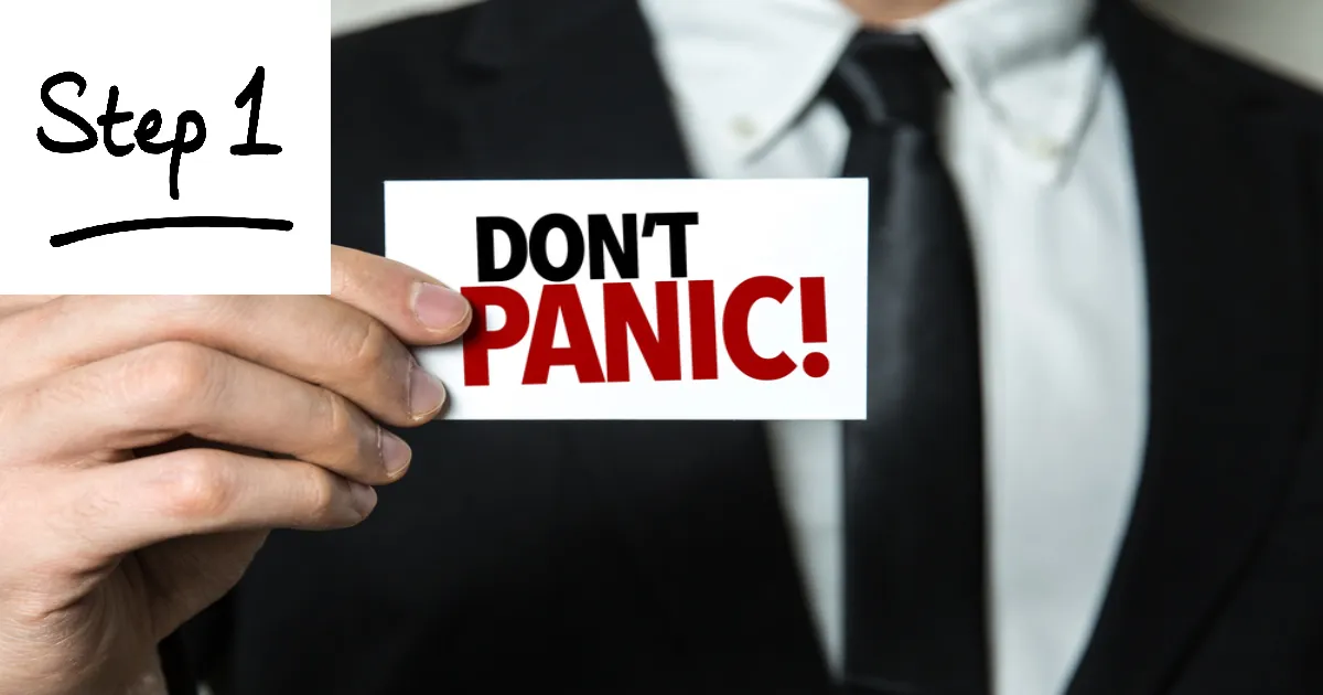 A man holding a note that says don't panic
