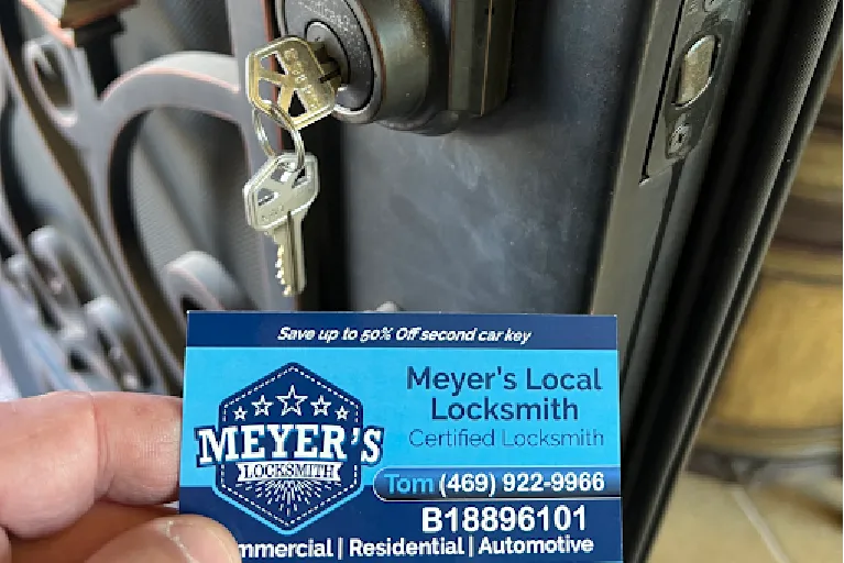 Meyer’s Local Locksmith business card held in front of a residential smart lock with keys inserted, showing trusted and best rekeying services in Prosper TX