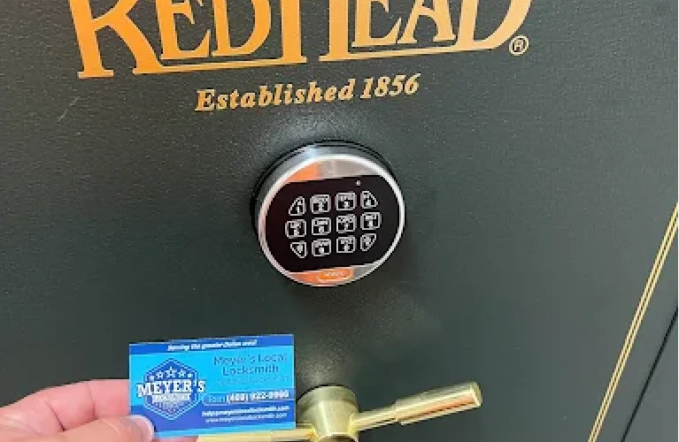 Local locksmith servicing an electronic keypad safe in Prosper, TX, with a Meyer’s Local Locksmith card shown.